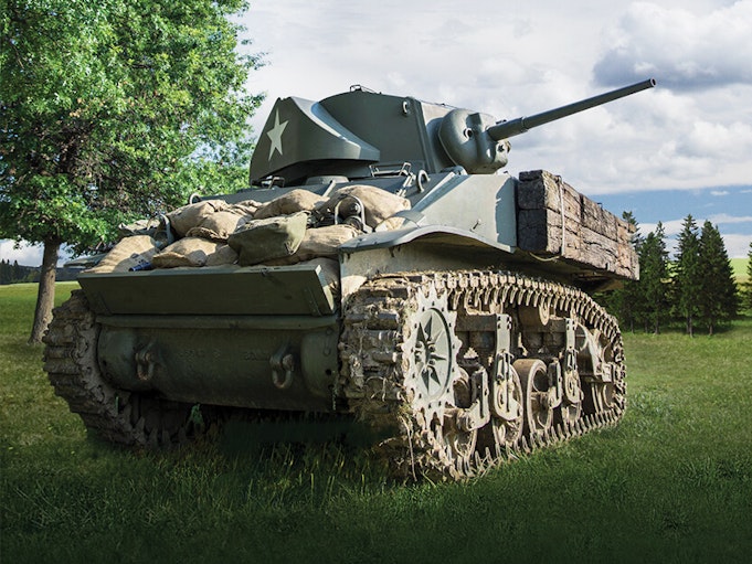 A collector military vehicle on a grassy lawn with blue sky in the background.