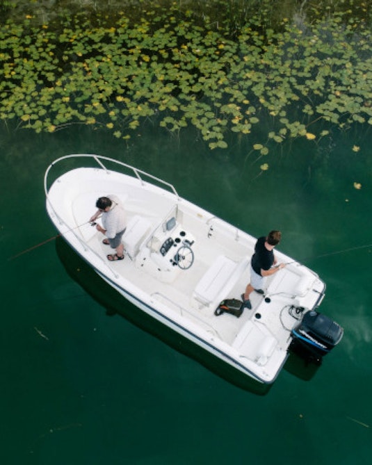 A small fishing boat by some lily pads