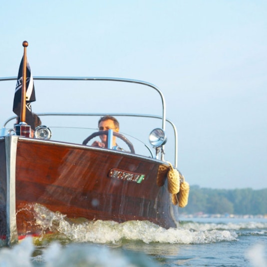 A man directing a collector boat through the water.